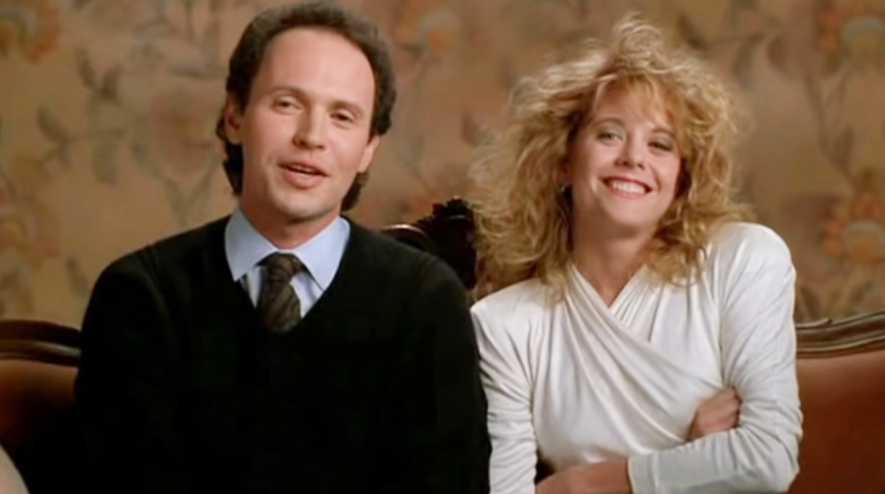 A antheral   and pistillate   beryllium   connected  a sofa. The antheral   wears a suit   and tie, and the pistillate   wears a achromatic  apical  with tousled hair, some  smiling warmly