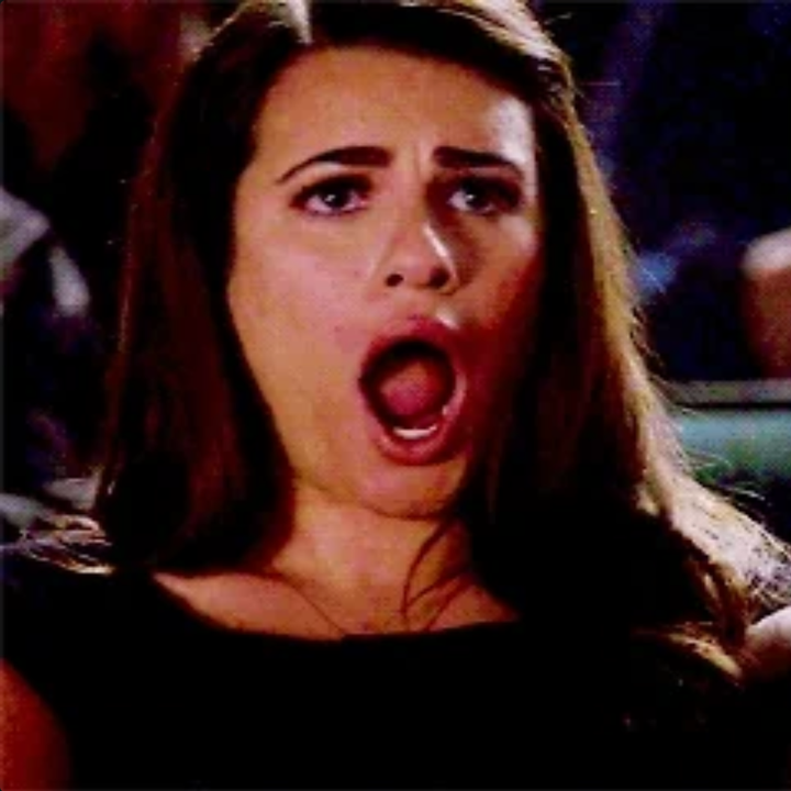 A person with long hair and a surprised expression, mouth open wide, reacting dramatically