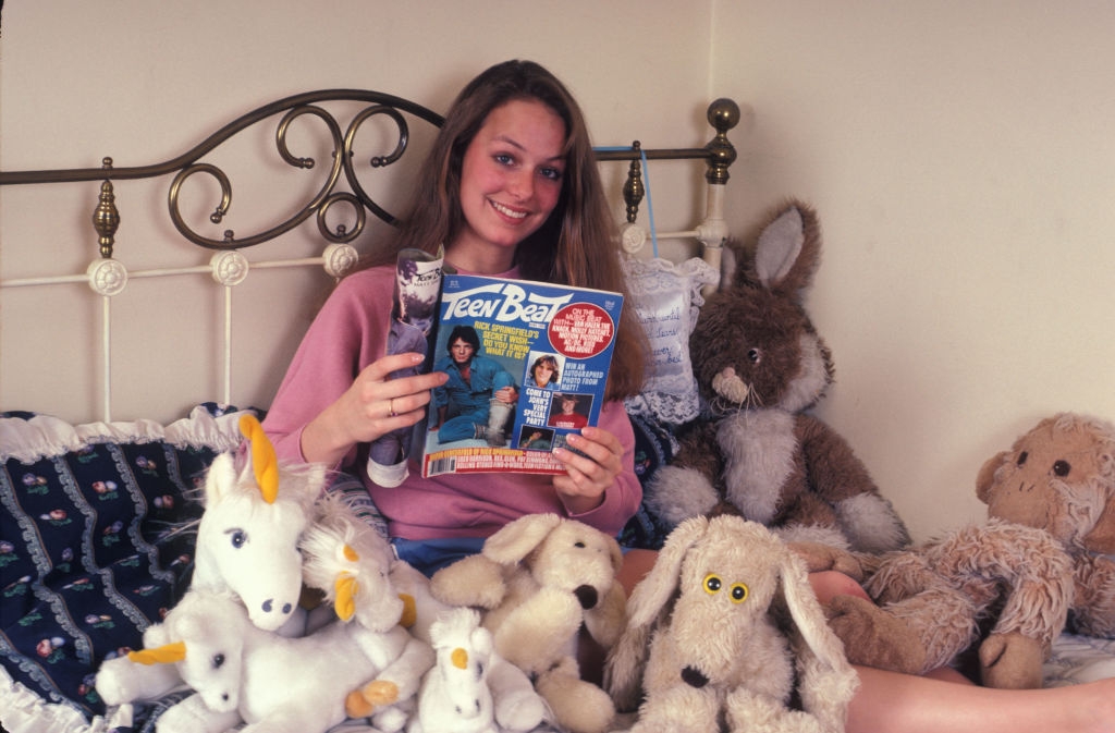 Hardin on a bed with stuffed animals, holding a "Teen Beat" magazine featuring celebrities