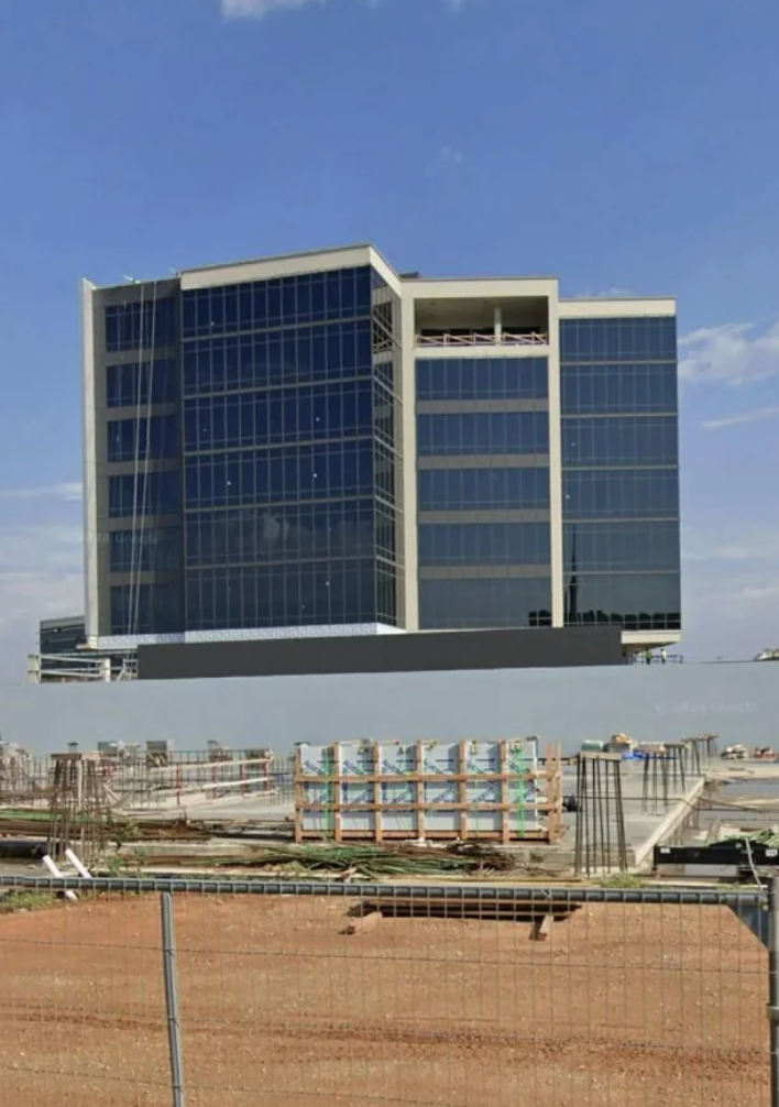 Construction tract  of a modern, multi-story solid  bureau   gathering  with scaffolding and materials successful  the foreground