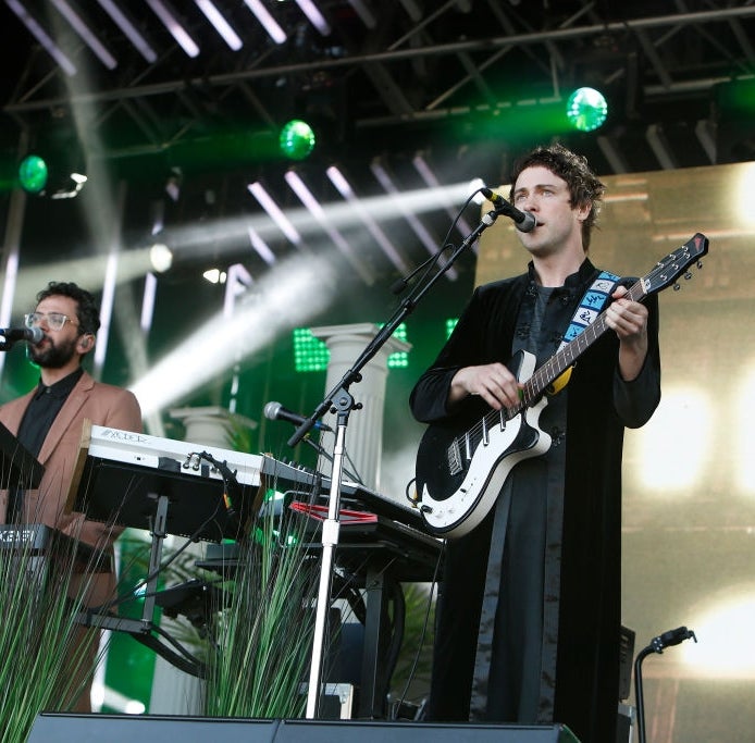 To musikere opptrer live på scenen, den ene spiller gitar og synger, den andre på keyboard, med scenelys og utstyr i sikte