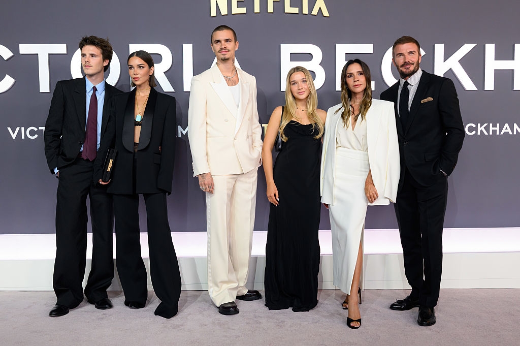 Group of six radical   astatine  a Netflix event, wearing ceremonial  and semi-formal attire, lasting  successful  beforehand   of a backdrop