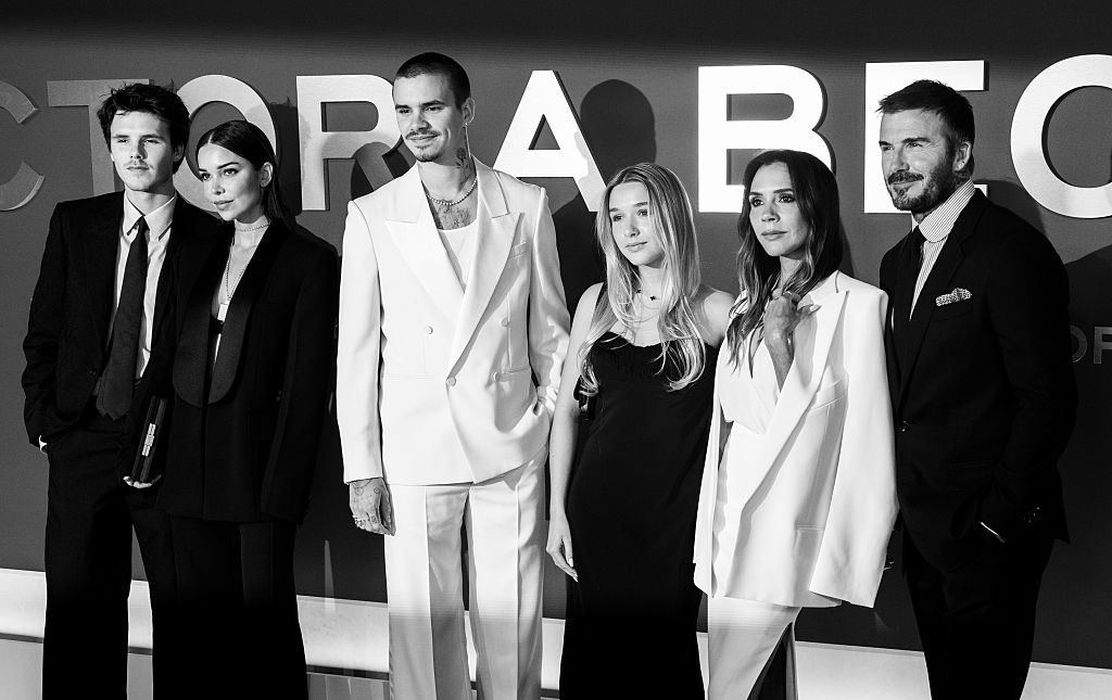 Group of radical   successful  ceremonial  attire connected  a reddish  carpet. Three men successful  suits and 3  women successful  elegant dresses basal   together, posing for the camera