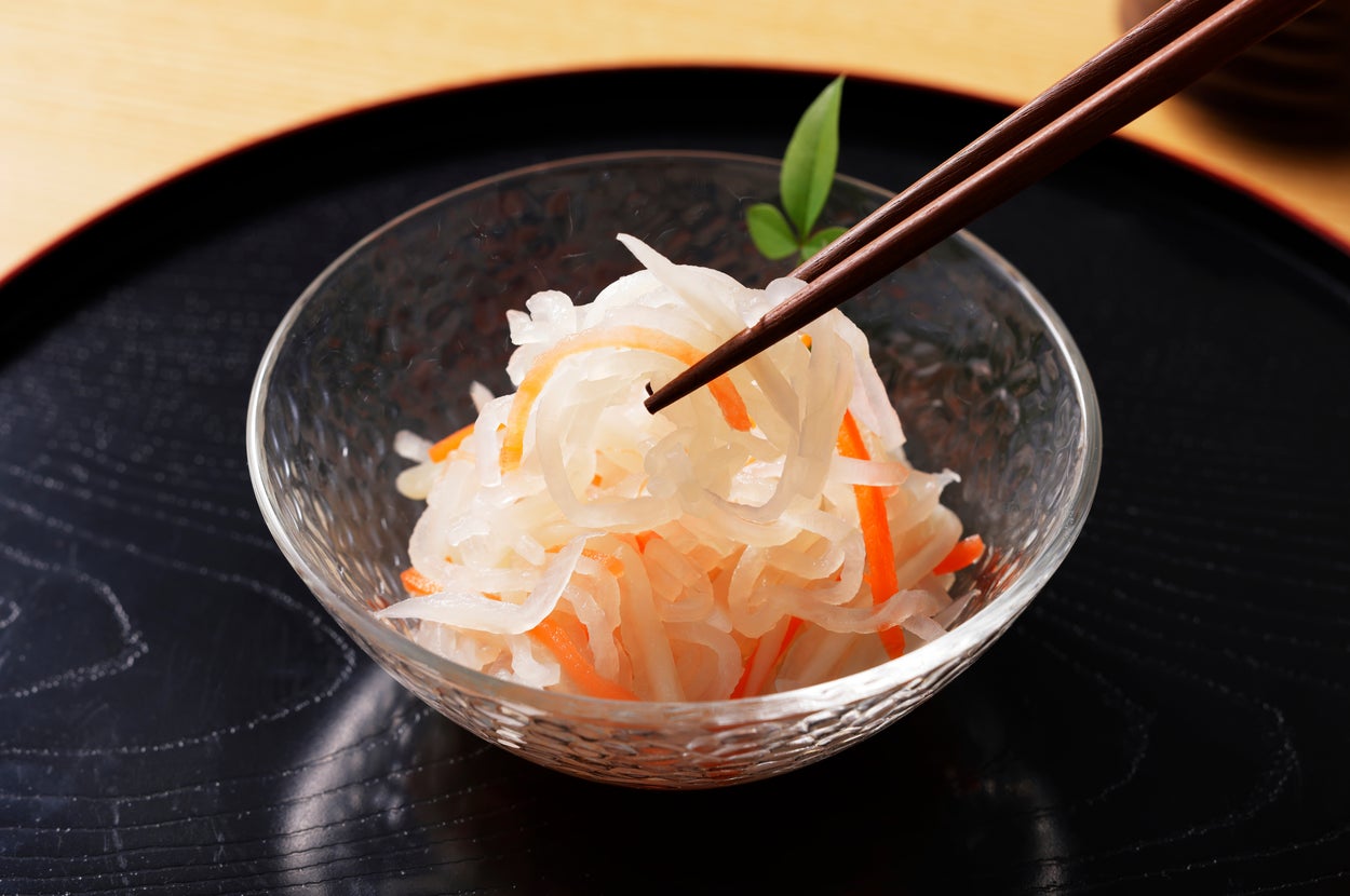 ガラスの器に盛られたなますが箸でつままれている。