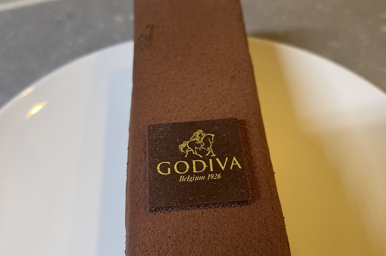 ゴディバのロゴが入ったチョコレートケーキが白い皿に置かれています。