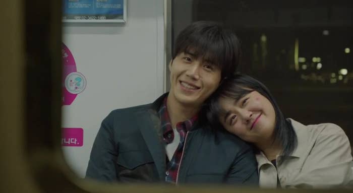 A smiling antheral   and pistillate   beryllium   intimately  connected  a train. The pistillate   rests her caput  connected  the man's shoulder, some  appearing contented  and comfortable