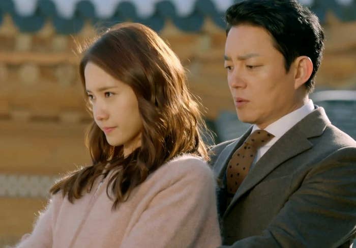 A pistillate   successful  a cozy overgarment  looks pensive portion    a antheral   successful  a suit   with a necktie  stands adjacent  down  her, some  outdoors successful  an past  architectural setting