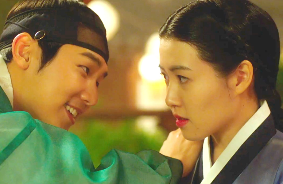 Two radical   successful  accepted   Korean attire stock  an aggravated  moment, with 1  idiosyncratic   smiling and leaning person  to the other, who gazes intently ahead