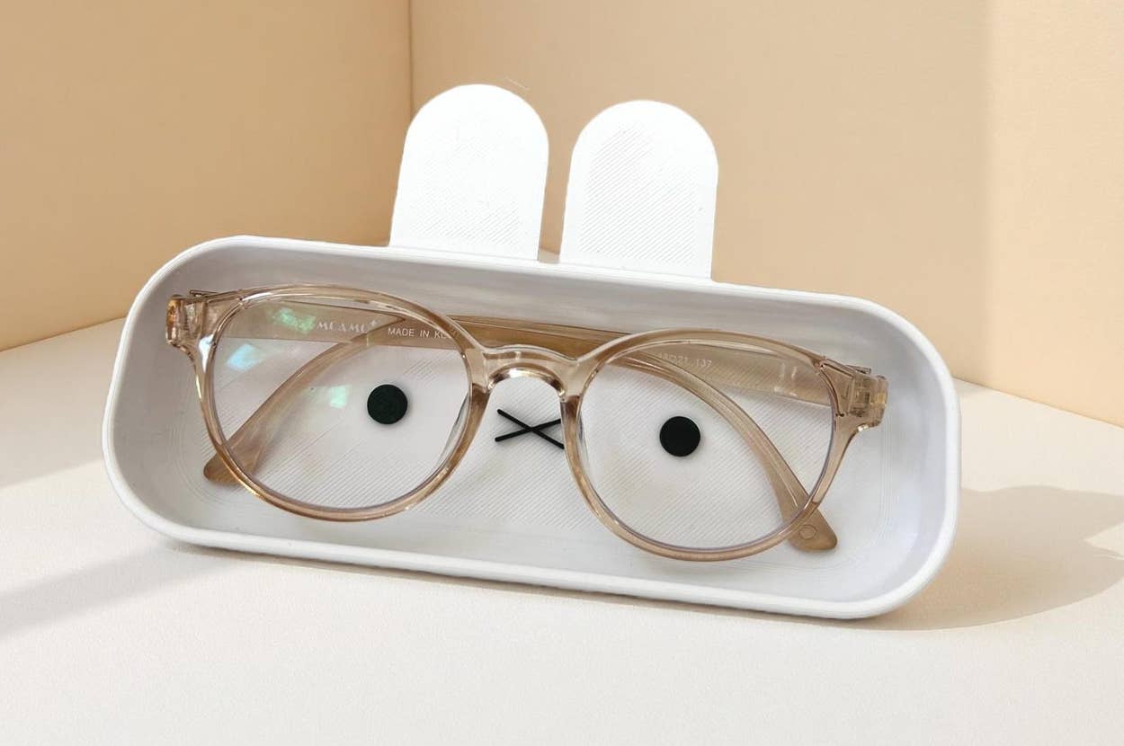 Cute, bunny-shaped eyeglass holder with glasses on display, ideal for organizing eyewear stylishly. Perfect for home or office decor