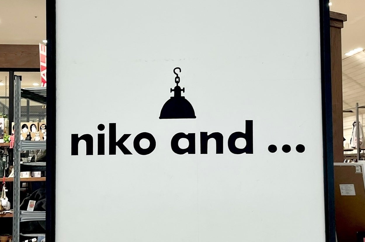 「niko and …」の店の看板。中央に小さなランプのシルエット。