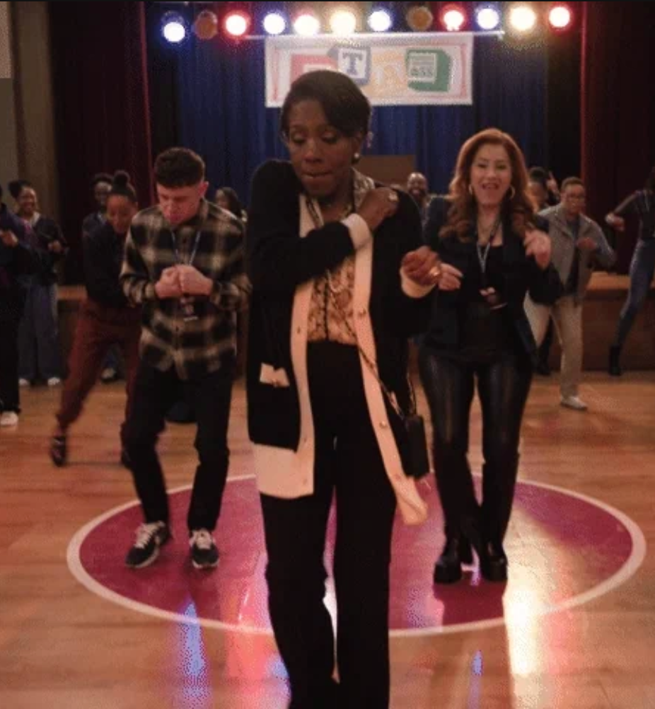 People dancing successful a lively radical connected a stage, with 1 idiosyncratic leading. They are wearing stylish, casual outfits. Stage lights are disposable down them