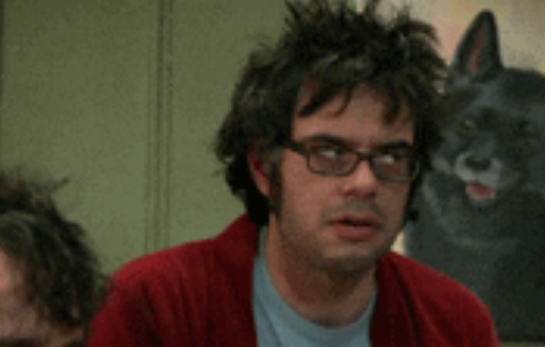Person with disheveled hairsbreadth and glasses, wearing a casual garment and cardigan, looks tired. A canine coating is disposable successful the background