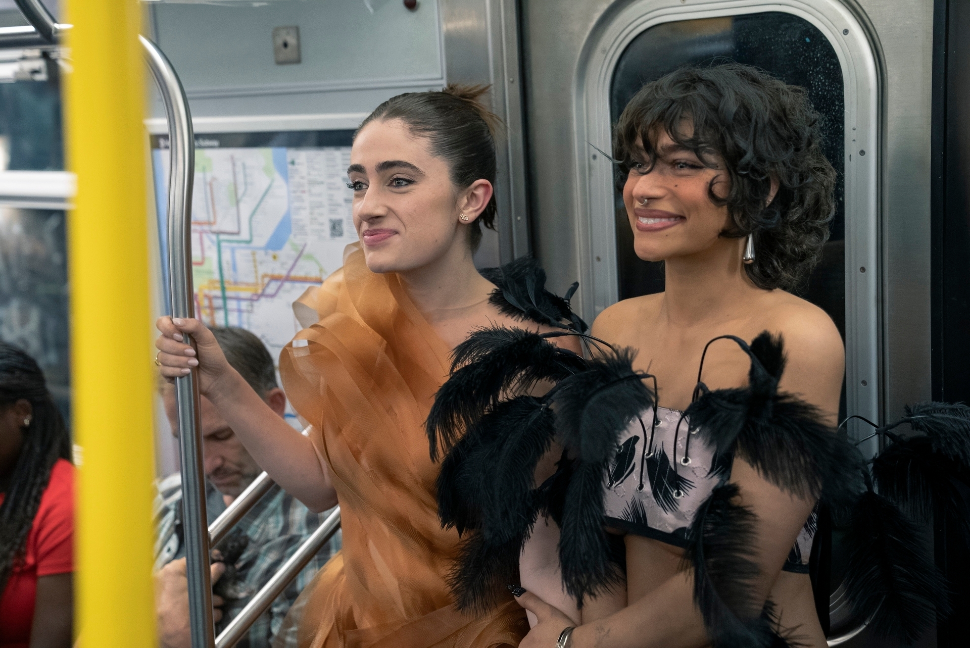 Two radical successful stylish, feathered outfits are lasting connected a subway train, smiling