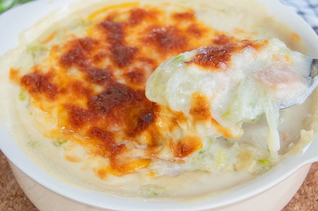 クリーミーな白菜グラタンのアップ。とろけたチーズがかかり、スプーンですくわれている。