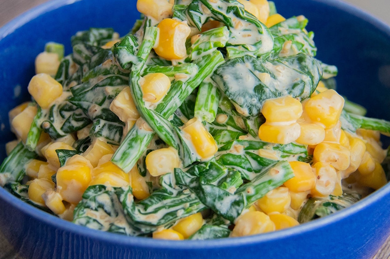 青いボウルに盛られたほうれん草とコーンの和風マヨサラダ。