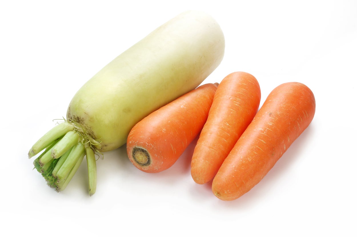 大根と3本のにんじんが白い背景に置かれています。