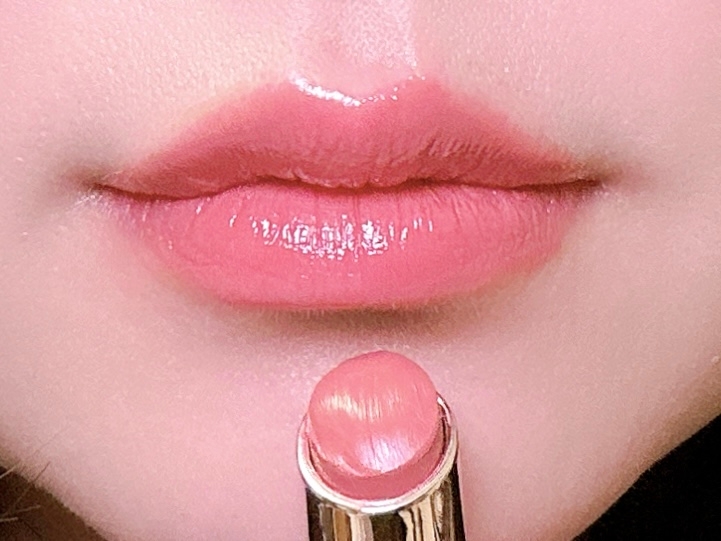 口紅を塗る唇のクローズアップ。光沢のある仕上がりを強調。