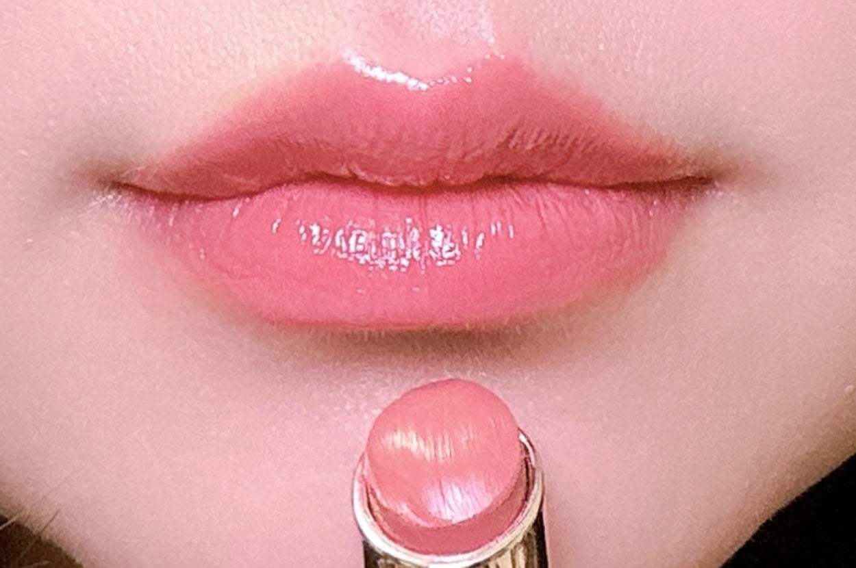 口紅を塗る唇のクローズアップ。光沢のある仕上がりを強調。