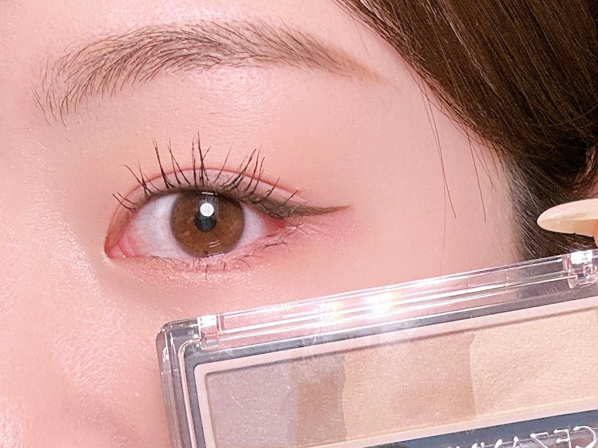 アイメイクをした人物の目元とアイシャドウパレットが映っている。