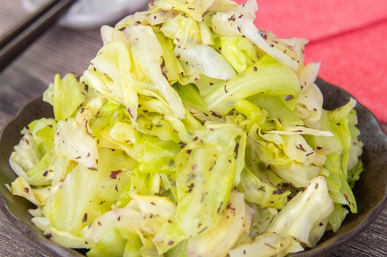 キャベツの赤しそナムルが皿に盛られており、テーブルにはお箸が置かれている。