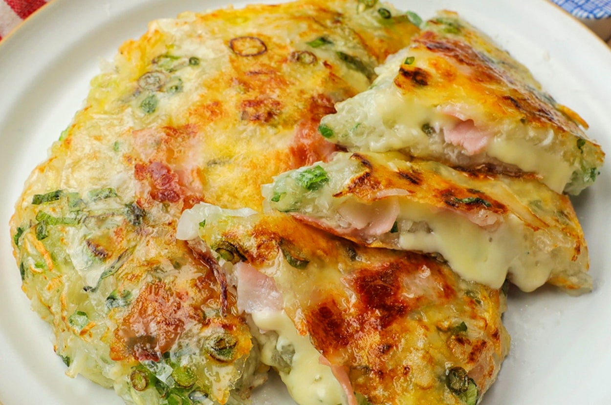 チーズとネギが入った韓国風チヂミが白い皿に盛られている。