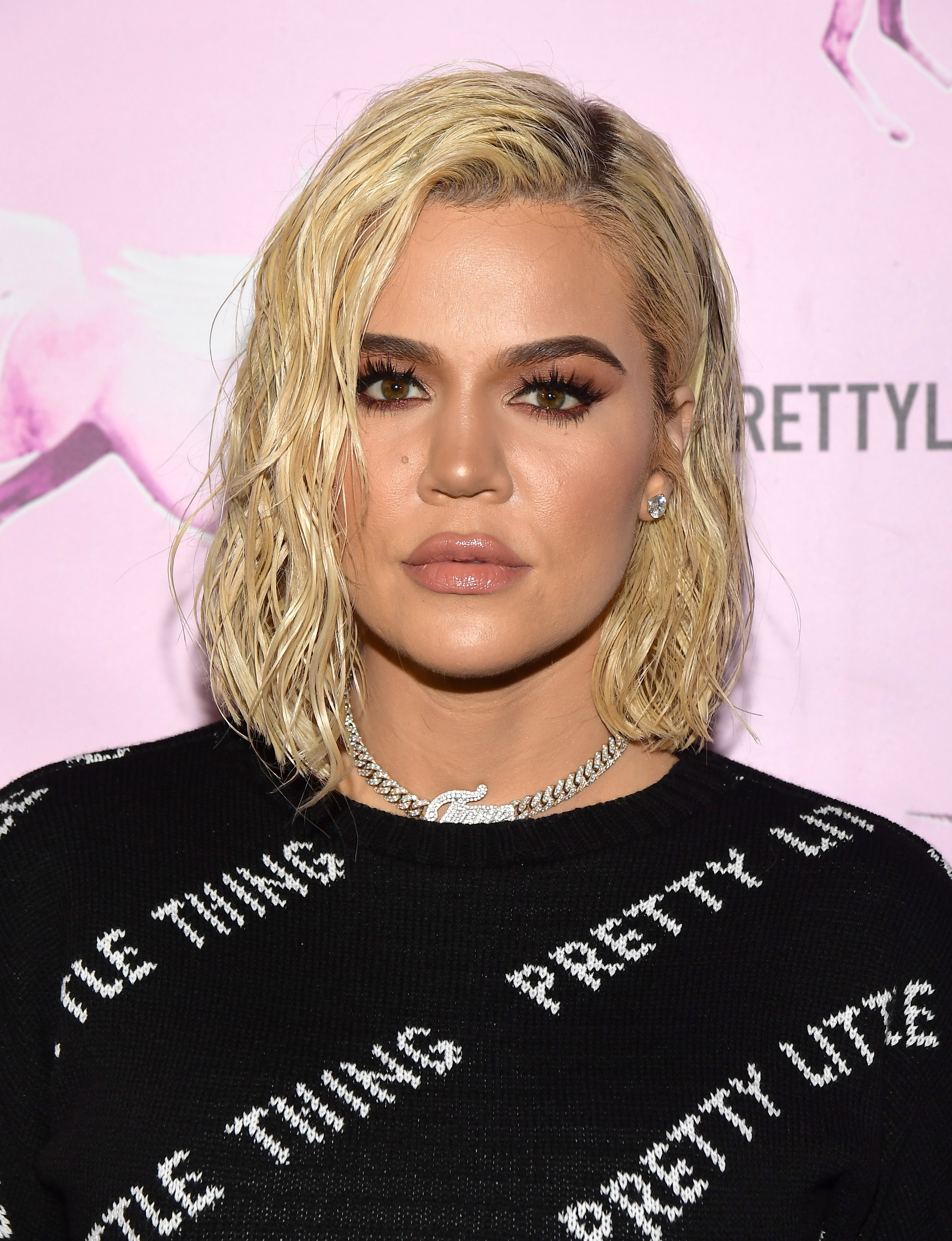 Khloe Kardashian with wavy abbreviated  hairsbreadth  wears a chic printed apical  and connection    necklace astatine  a personage  event