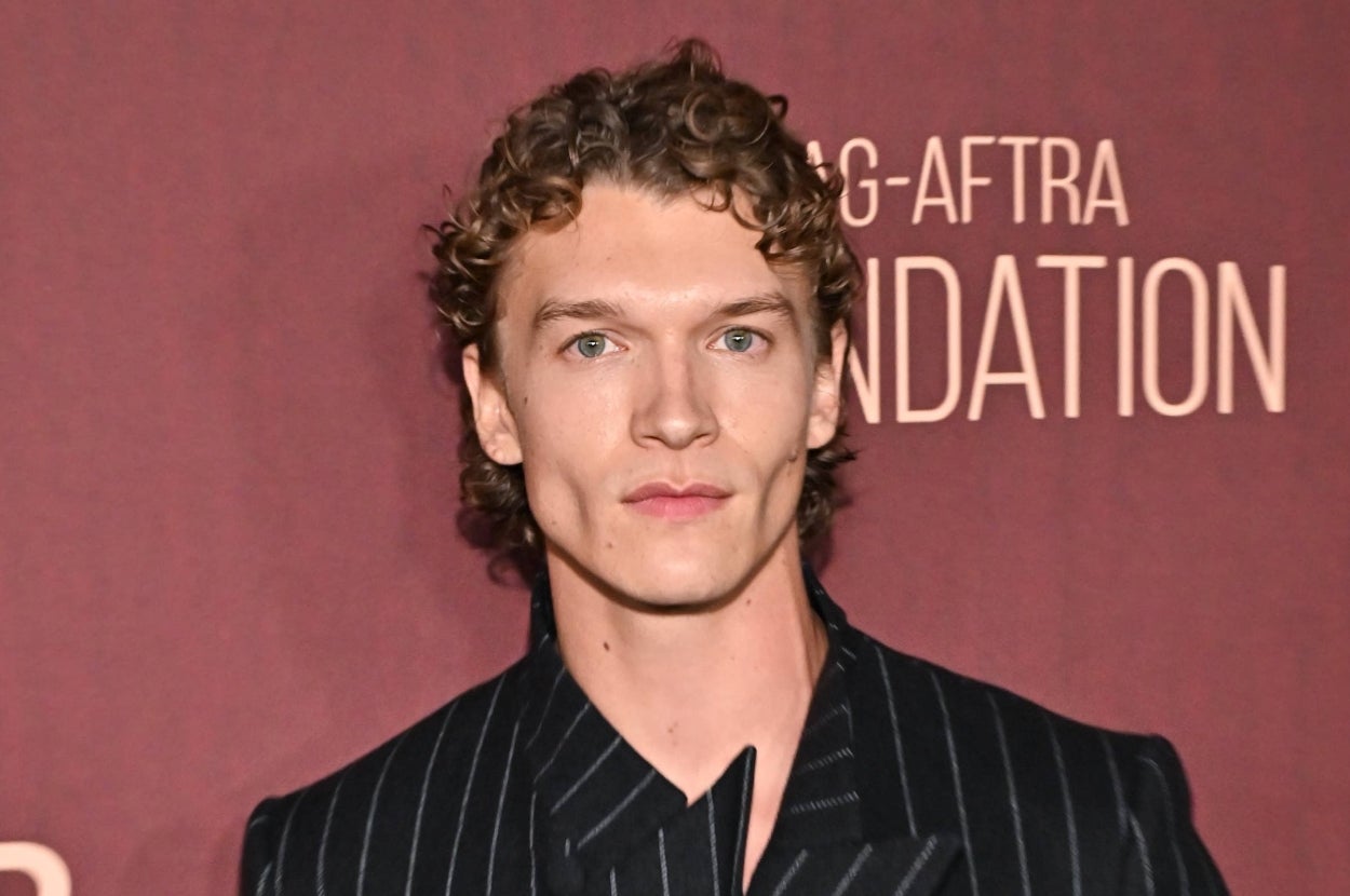 Person in a pinstripe jacket at a celebrity event with a backdrop featuring the SAG-AFTRA Foundation logo