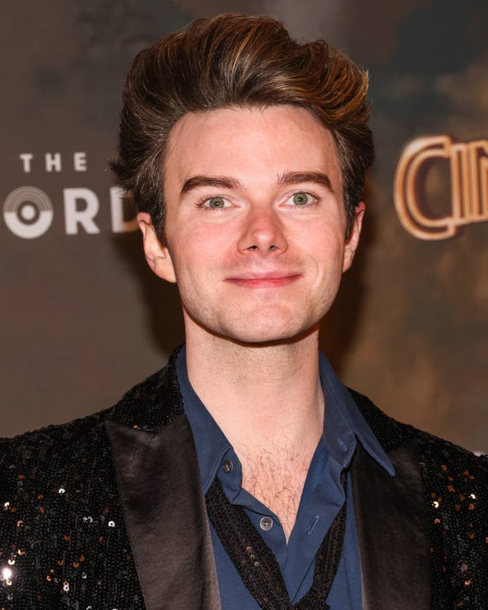 Chris Colfer connected  a reddish  carpet wearing a sequin jacket, bluish  shirt, and escaped   tie, smiling astatine  the camera