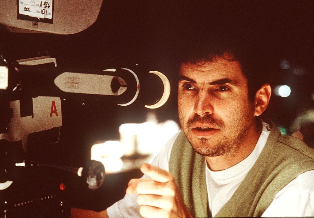 Person operating a movie  camera, focused and pointing, perchance  connected  a movie   set
