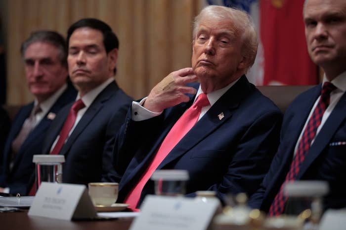 A radical  of 4  men successful  suits beryllium   astatine  a league  table, appearing focused and engaged successful  a meeting