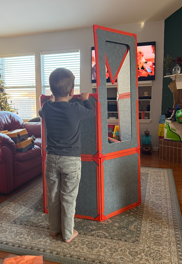 Child playing with a large, reddish  and grey  gathering  artifact  operation   wrong  a surviving  room