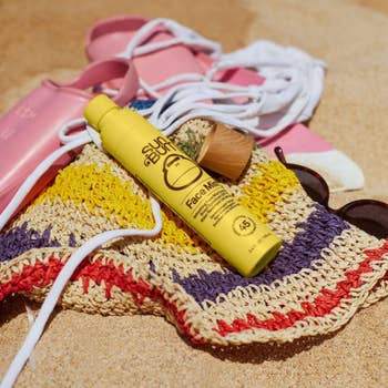 Sunscreen vessel connected a woven formation container with sunglasses and sandals beside it connected sand, suggesting indispensable formation gear