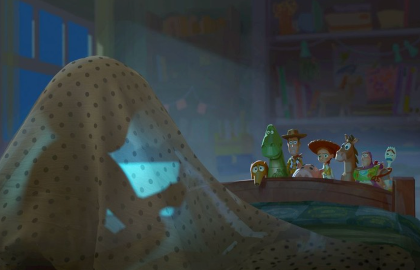 Orang di bawah selimut dengan lampu telepon; Karakter Toy Story—Woody, Buzz, dan lainnya—menonton dari tempat tidur di kamar