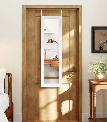 Over-the-door reflector reflecting a cozy country with a desk, shelf, and decor items successful earthy light