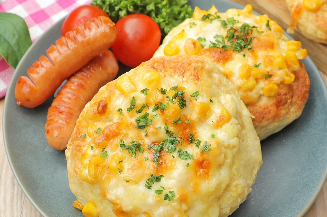 ソーセージ、トマト、コーンパン、レタスが盛り付けられたプレート。