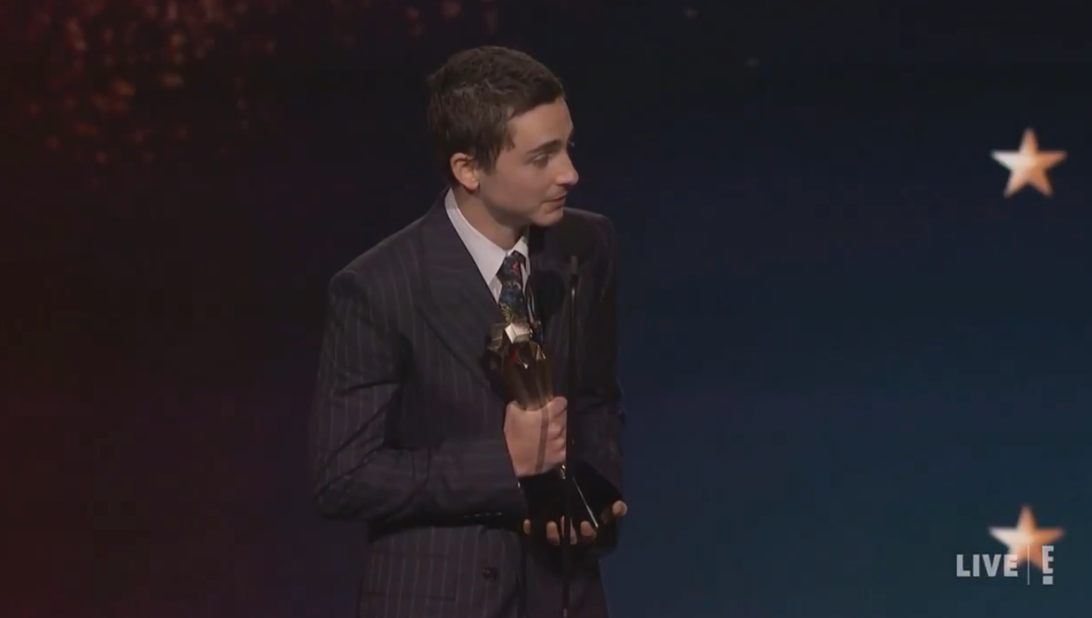 A idiosyncratic   successful  a suit   holds an grant  and speaks connected  signifier    during a unrecorded  event