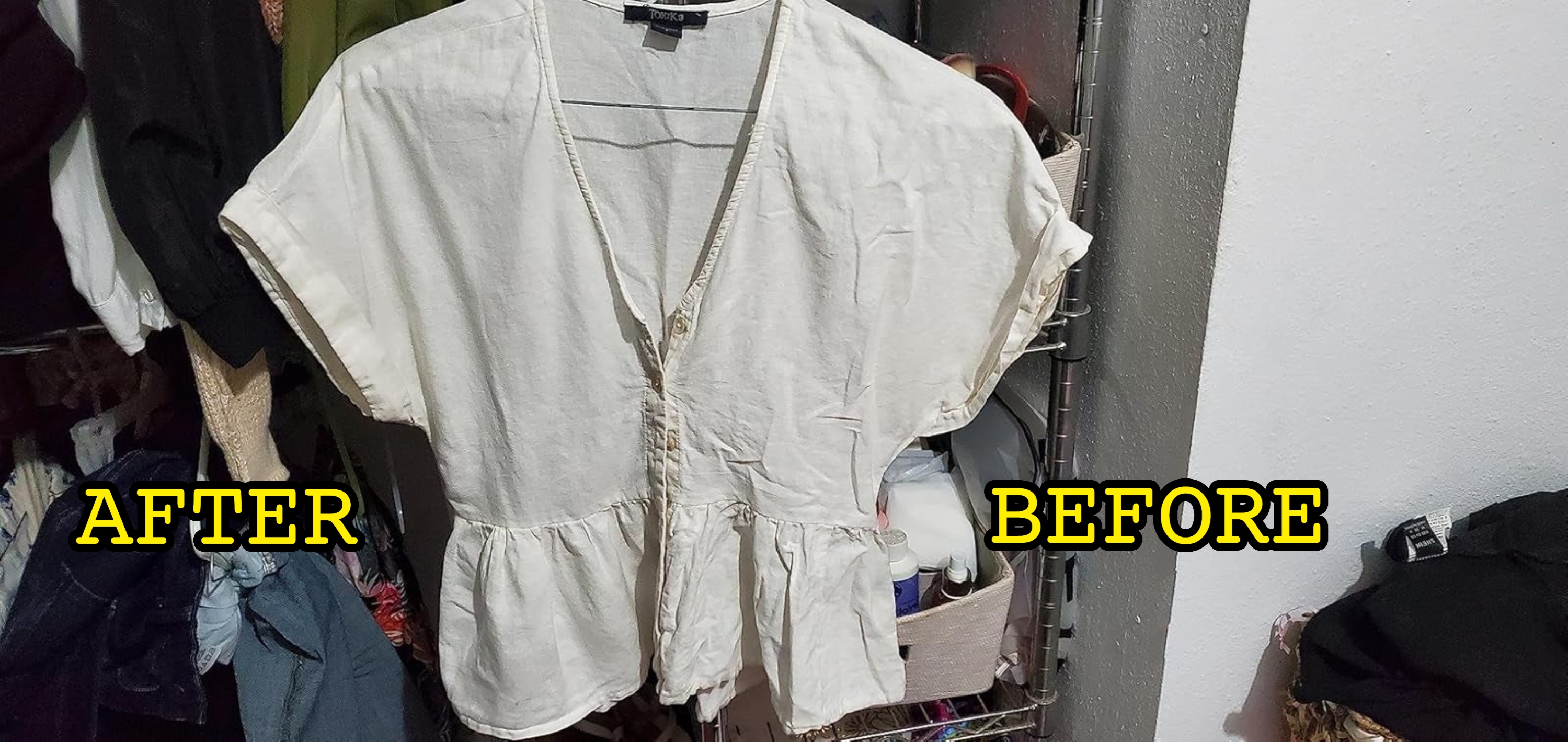 A cream-colored blouse with short sleeves and a peplum hem hangs in a closet, showcasing casual, feminine style fashion for shopping contexts
