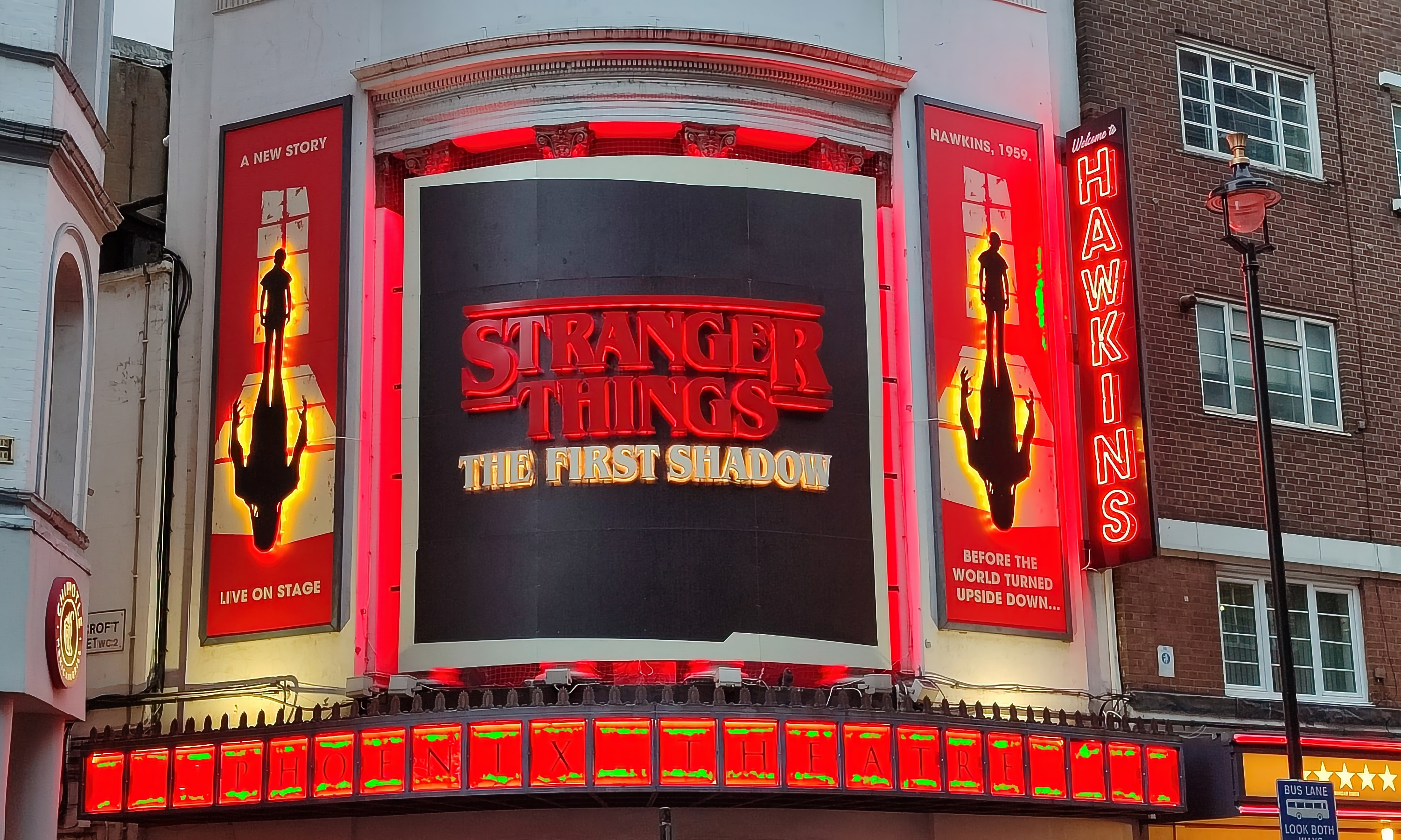 Teaterteltet viser "Stranger Things: The First Shadow" live på scenen, med silhuettbilder og lys skilting for Hawkins-settingen