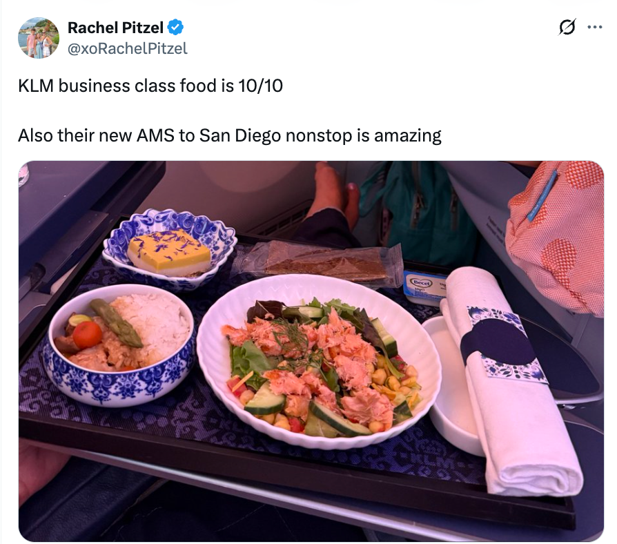 Brett med KLM business class mat med salat, tilbehør, brød og rullet serviett, rost for kvalitet i en tweet