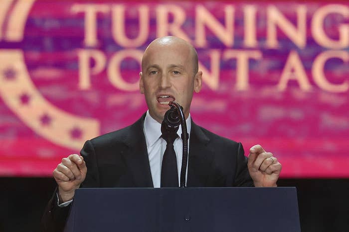 A person in a suit is speaking into a microphone at a podium during a Turning Point event