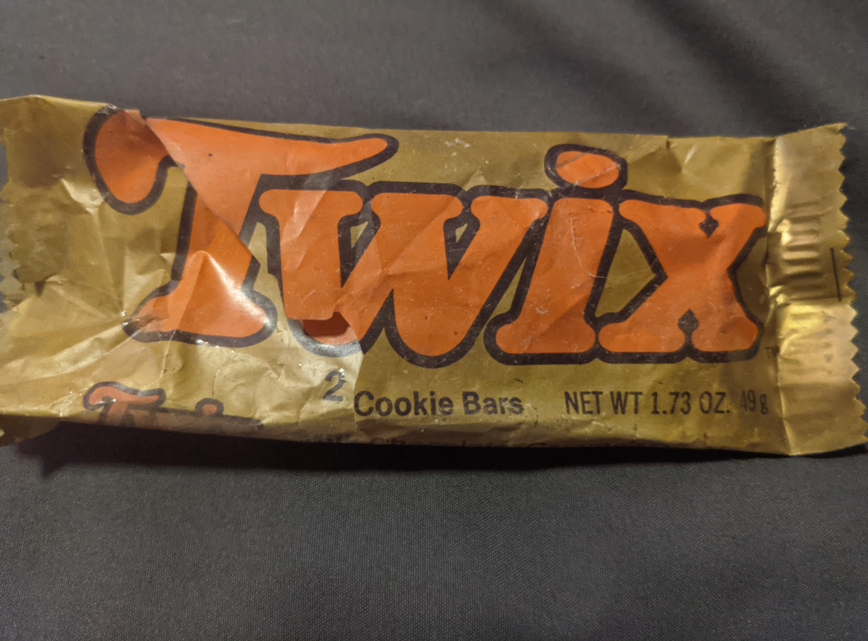 Twix candy wrapper showing it contains two cookie bars, net weight 1.73 oz (49g)