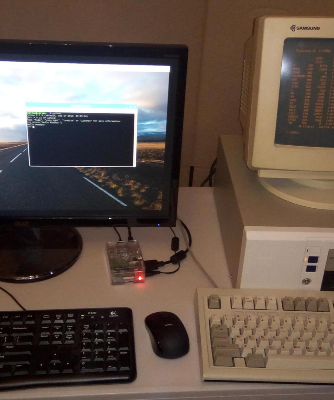 Two computer setups: One modern with a flat screen showing a road and OS, and a vintage setup with a bulky monitor displaying orange text