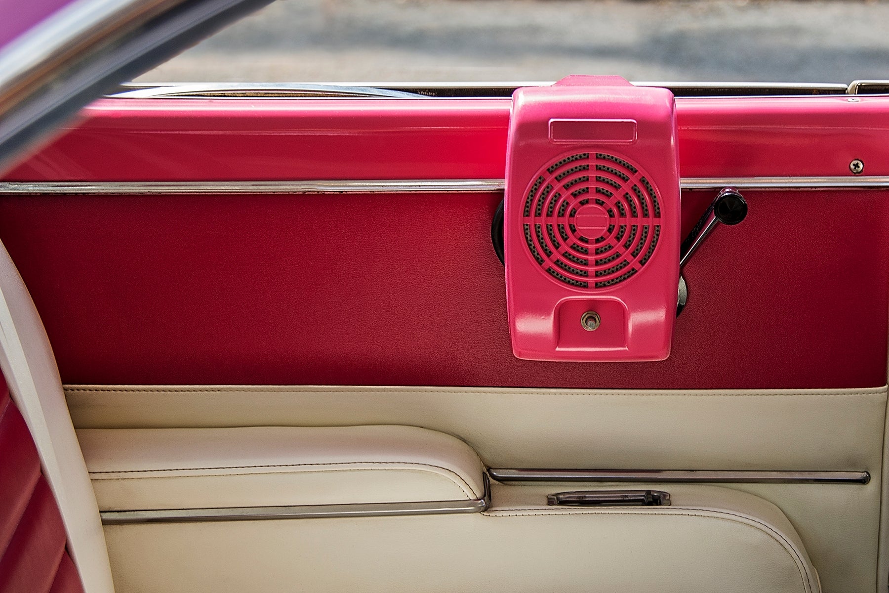 Drive-in movie   theatre  talker  attached to a classical  car   door, evoking a nostalgic household  outing setting