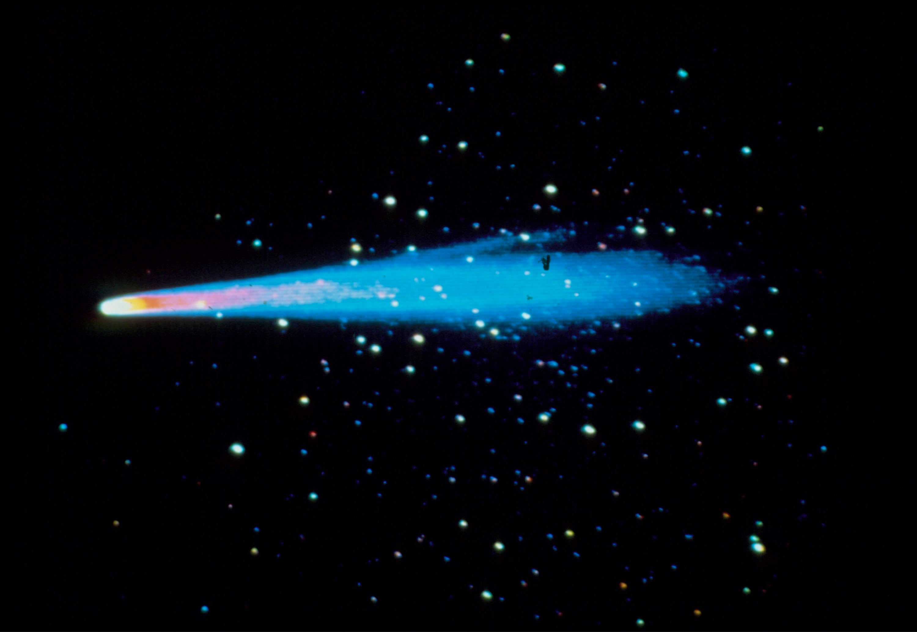 A agleam  comet with a glowing process    streaks crossed  a starry sky, creating a celestial display