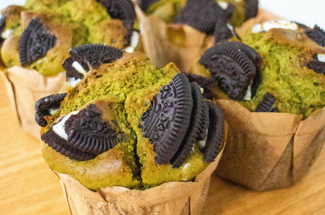 緑茶のマフィンにチョコクッキーが添えられ、木の板の上に4個並べられています。