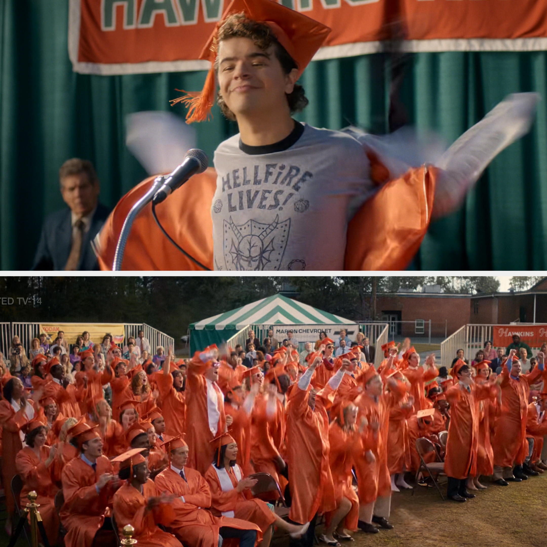 Teen removes graduation gown on stage, revealing a "Hellfire Lives!" shirt as classmates cheer