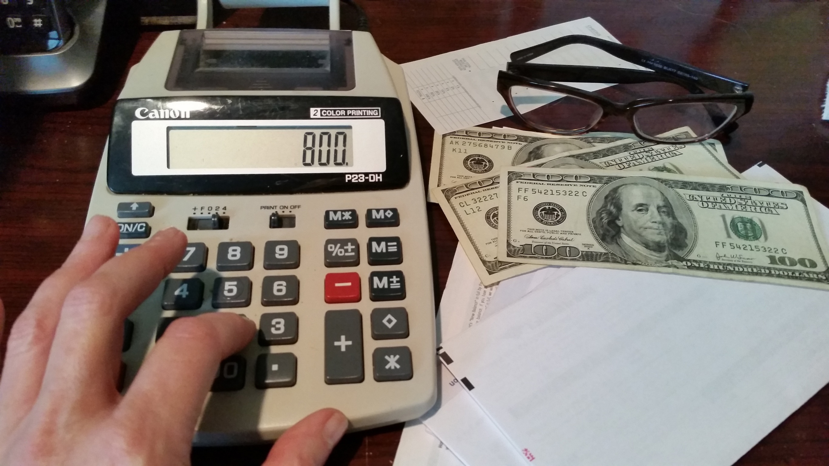 Hånd som bruker en kalkulator som viser 