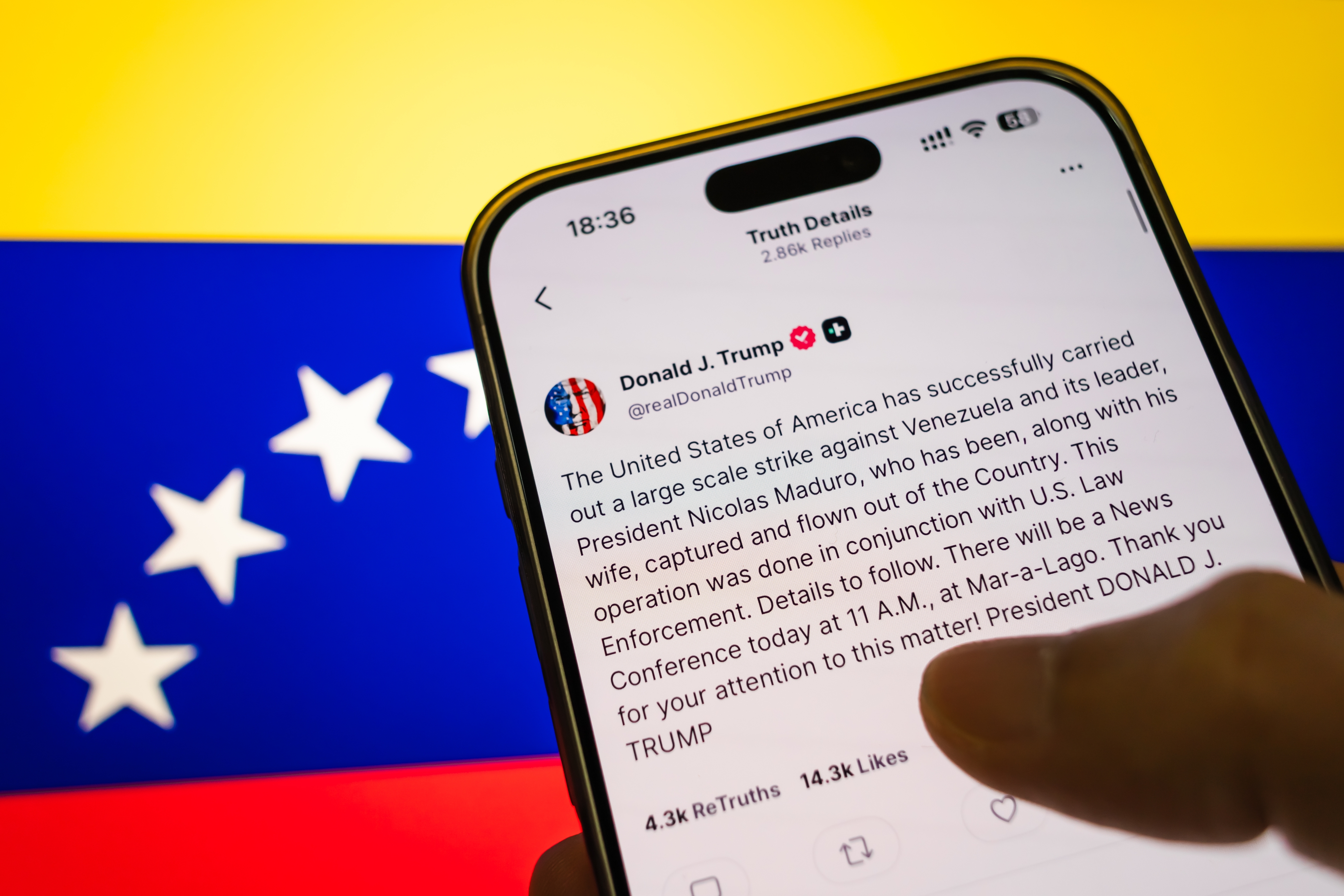 En smarttelefon viser et innlegg angivelig fra Donald Trump som hevder vellykkede luftangrep i Venezuela, mot Nicolas Maduro. Det venezuelanske flagget er i bakgrunnen