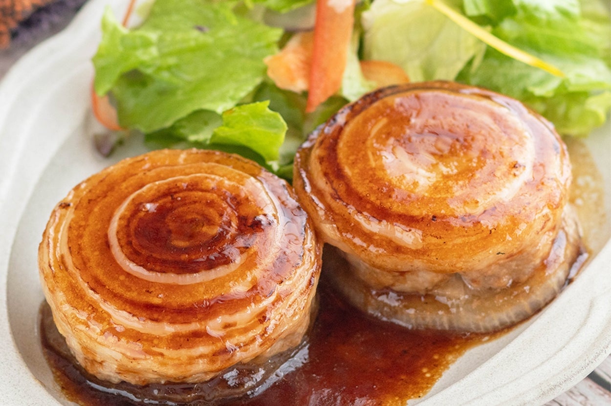 皿に盛られた2つのソースがけハンバーグとサラダ。