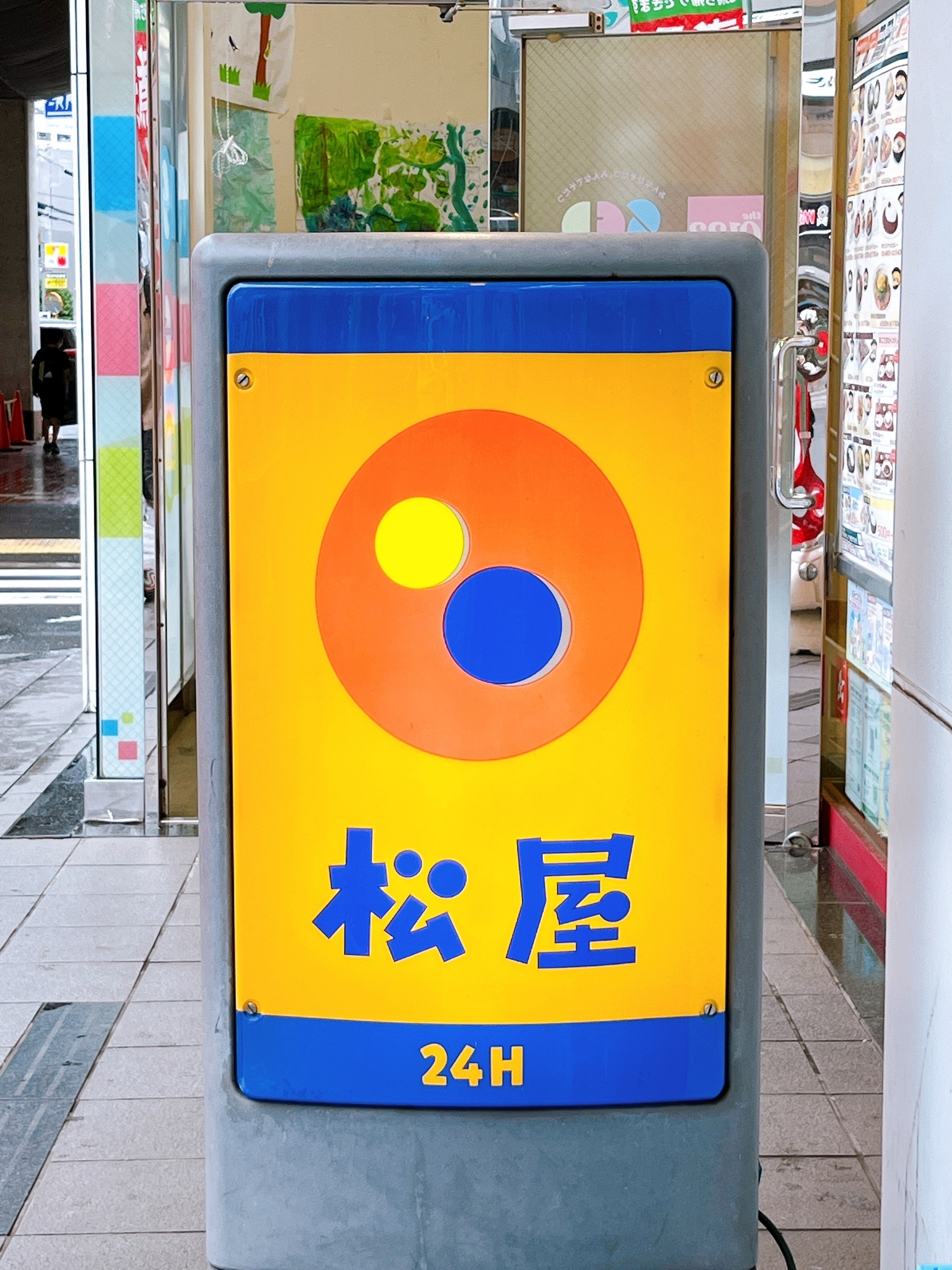 看板に「松屋」と書かれ、24時間営業の表示があります。